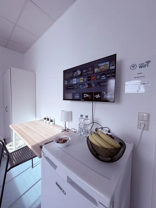 Zimmer mit Kühlschrank und Fernseher